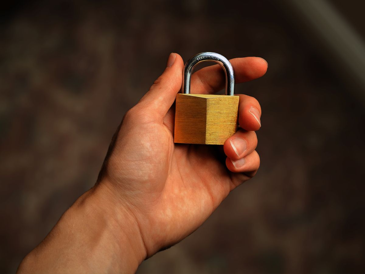 Main tenant un cadenas en laiton